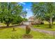 Beautiful home exterior with lush green lawn, mature trees, and a convenient two-car garage and long drive at 296 Hicks Creek Rd, Troutman, NC 28166