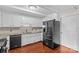 Modern kitchen with granite countertops, stainless steel appliances, tiled backsplash, and a black refrigerator at 296 Hicks Creek Rd, Troutman, NC 28166