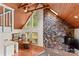 Living room featuring a stone accent wall, wood ceiling, hardwood floors and natural light from large windows at 296 Hicks Creek Rd, Troutman, NC 28166