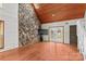 Spacious living room with hardwood floors, a striking stone accent wall, and bright natural light at 296 Hicks Creek Rd, Troutman, NC 28166