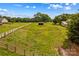 Wide angle view of expansive horse property with wooden fencing, trees and outbuildings on a bright day at 296 Hicks Creek Rd, Troutman, NC 28166