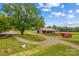 Rural property featuring a barn, a large tree, and a gravel driveway at 296 Hicks Creek Rd, Troutman, NC 28166