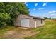 Exterior view of metal shed with roll up door on grassy lot, close to tree line at 296 Hicks Creek Rd, Troutman, NC 28166