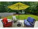 Outdoor patio with umbrella offers ample seating for relaxing and entertaining in a wooded, private yard at 3005 Streamlet Way, Monroe, NC 28110