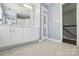 Bright bathroom with double vanity, patterned floors, and a doorway to a staircase at 3005 Streamlet Way, Monroe, NC 28110