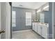 Bright bathroom with double vanity, patterned floors, and neutral gray wall paint at 3005 Streamlet Way, Monroe, NC 28110