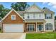 Charming two-story home featuring stone accents, a two-car garage, and a welcoming front porch at 3005 Streamlet Way, Monroe, NC 28110