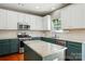 Well-lit kitchen featuring an island, stainless steel appliances, and a window with plants at 3005 Streamlet Way, Monroe, NC 28110