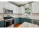 A kitchen featuring stainless steel appliances, granite countertops, and teal colored lower cabinets at 3005 Streamlet Way, Monroe, NC 28110