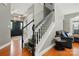 Welcoming foyer with staircase featuring black and white accents, complemented by hardwood flooring at 3005 Streamlet Way, Monroe, NC 28110