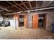 Unfinished basement with concrete walls and floors, wood ceiling, and access to other rooms at 3158 Salisbury Hwy, Statesville, NC 28677