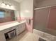 A pink tiled bathroom featuring a vanity with under-cabinet storage and a tub/shower combination at 3158 Salisbury Hwy, Statesville, NC 28677
