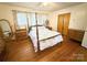 Bedroom featuring hardwood floors, a four-poster bed, and natural light from the windows at 3158 Salisbury Hwy, Statesville, NC 28677