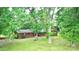 Exterior shot of a brick home with a sprawling yard surrounded by tall, mature trees at 3158 Salisbury Hwy, Statesville, NC 28677