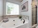 Bathroom showcasing a soaking tub and a shower with stone accents and decorative wainscoting at 3347 Xandra Ct, Indian Land, SC 29707