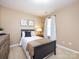 Cozy bedroom featuring neutral walls, stylish decor, and a comfortable bed near a sunlit window at 3347 Xandra Ct, Indian Land, SC 29707