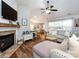 Comfortable living area boasts a brick fireplace, ceiling fan, and hardwood flooring at 3347 Xandra Ct, Indian Land, SC 29707