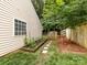 Home's side yard featuring a garden with stepping stones, a wood fence, and healthy greenery at 3347 Xandra Ct, Indian Land, SC 29707