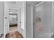 Bathroom featuring open doorway to bedroom, shower with glass door, and wood look flooring at 3419 Brickyard Ln, Midland, NC 28107