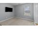 Well-lit bedroom with neutral carpet, a window, a TV mounted to the wall, and a clean and simple design at 3419 Brickyard Ln, Midland, NC 28107