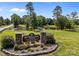 Entrance sign for Rob Wallace Park with stone accents, lush landscaping, and a glimpse of the pond at 3419 Brickyard Ln, Midland, NC 28107
