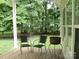 Covered porch featuring outdoor seating and views of the serene, tree-lined backyard at 390 Robinson Rd, Mooresville, NC 28117