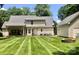 Large, well-maintained backyard with lush green grass, an outdoor fire pit, and a detached garage at 390 Robinson Rd, Mooresville, NC 28117