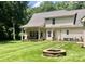 Spacious backyard with lush green grass, an outdoor fire pit, and covered porch at 390 Robinson Rd, Mooresville, NC 28117