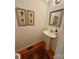 Powder room featuring a pedestal sink, framed mirror, and decorative art above wood flooring at 390 Robinson Rd, Mooresville, NC 28117