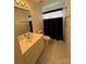 Cozy bathroom featuring a vanity with storage, tub with shower curtain, and ceramic tile flooring at 390 Robinson Rd, Mooresville, NC 28117
