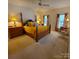 Spacious bedroom featuring a wooden four-poster bed, soft carpet, and two large windows with plenty of natural light at 390 Robinson Rd, Mooresville, NC 28117