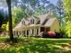 Traditional two-story home with a covered front porch and colorful landscaping at 390 Robinson Rd, Mooresville, NC 28117