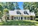 Charming one-story home featuring a manicured lawn, white trim, dormer windows, and welcoming front porch at 390 Robinson Rd, Mooresville, NC 28117
