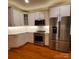 Kitchen showcasing stainless steel appliances, white cabinets, and hardwood floors at 390 Robinson Rd, Mooresville, NC 28117