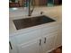 A close-up of the kitchen sink with white cabinets and subway tile backsplash at 390 Robinson Rd, Mooresville, NC 28117