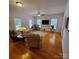 Hardwood floored living room with plants, lamps, comfortable seating, and natural light at 390 Robinson Rd, Mooresville, NC 28117