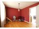 Bright dining room with hardwood floors, red accent wall, and view into adjacent eat-in kitchen at 400 Majolica Rd, Salisbury, NC 28147