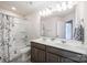 Bathroom featuring double vanity, gray cabinets, large mirror and shower/tub combo at 4012 Woodsmill Rd, Fort Mill, SC 29707