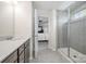 Bathroom with double sinks, gray cabinets, quartz countertops, tile flooring, and glass enclosed shower at 4012 Woodsmill Rd, Fort Mill, SC 29707