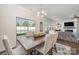Elegant dining area with a rustic table, upholstered chairs, and a view of the backyard at 4012 Woodsmill Rd, Fort Mill, SC 29707