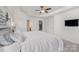 Bright main bedroom with white comforter, ceiling fan, and access to closet and bathroom at 4012 Woodsmill Rd, Fort Mill, SC 29707
