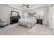Spacious main bedroom with a tray ceiling, ceiling fan, and natural light from two windows at 4012 Woodsmill Rd, Fort Mill, SC 29707