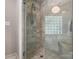 Walk-in shower featuring gray tile, a glass block window, and built-in bench seating at 4026 Sharon View Rd, Charlotte, NC 28226
