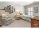 Cozy bedroom features a sitting chair, natural light, and unique framed artwork at 4026 Sharon View Rd, Charlotte, NC 28226
