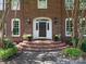 Elegant front door entrance with brick steps and black sconces for a welcoming facade at 4026 Sharon View Rd, Charlotte, NC 28226