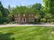 Beautiful brick home featuring manicured landscaping, mature trees, and a circular driveway at 4026 Sharon View Rd, Charlotte, NC 28226