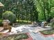 Outdoor patio area featuring a grill and seating for entertaining with lush greenery at 4026 Sharon View Rd, Charlotte, NC 28226