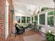 Relaxing sunroom with brick flooring, many windows, and comfortable seating at 4026 Sharon View Rd, Charlotte, NC 28226