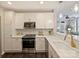 Modern white kitchen features stainless appliances, stylish lighting, and sleek countertops at 416 Queens Rd # 10, Charlotte, NC 28207