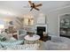 The open living room showcases fireplace, ceiling fan and flows into the dining area at 416 Queens Rd # 10, Charlotte, NC 28207